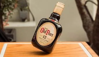 Garrafa de Old Parr sobre uma bancada de madeira
