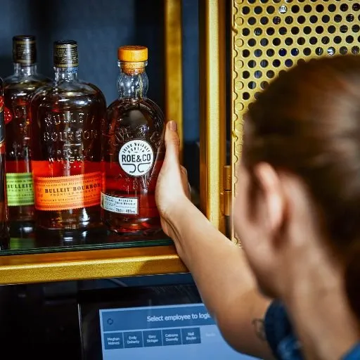 Bartender pegando garrafa na prateleira