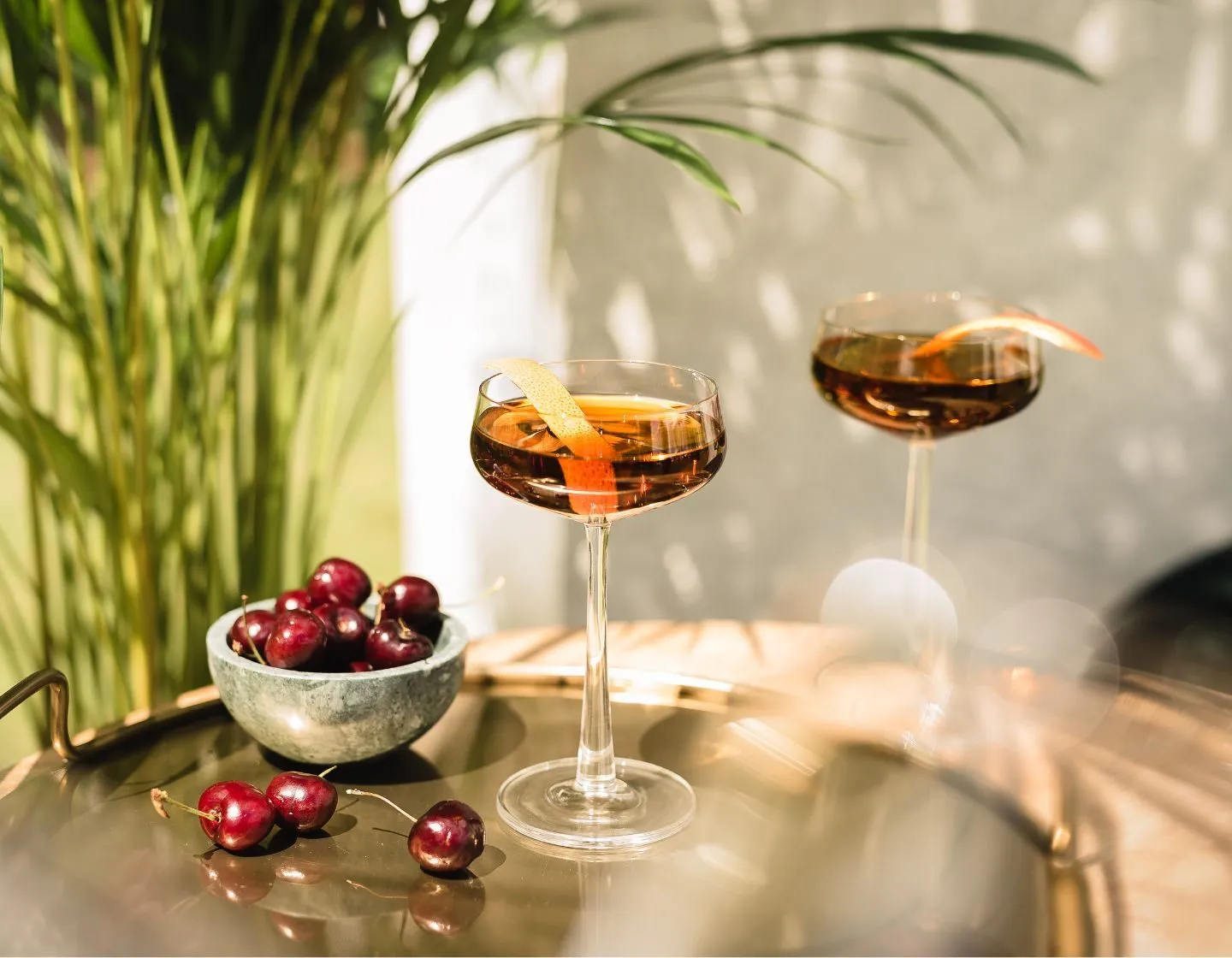 Duas taças de coquetel com rum Zacapa e uma tigela de cerejas
