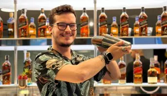 Ale Barberino, treinador do Diageo Bar Academy, sorrindo atrás do balcão