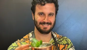 Douglas Horvath, treinador do Diageo Bar Academy, sorrindo atrás do balcão
