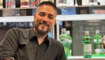 Erivelton Mota, treinador do Diageo Bar Academy, sorrindo atrás do balcão