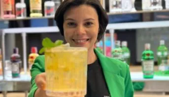 Fernanda Santos, treinador do Diageo Bar Academy, sorrindo atrás do balcão