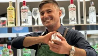 Marcelo Prantoni, treinador do Diageo Bar Academy, sorrindo atrás do balcão