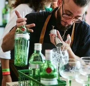  Imagem de um bartender despejando gin com um dosador 