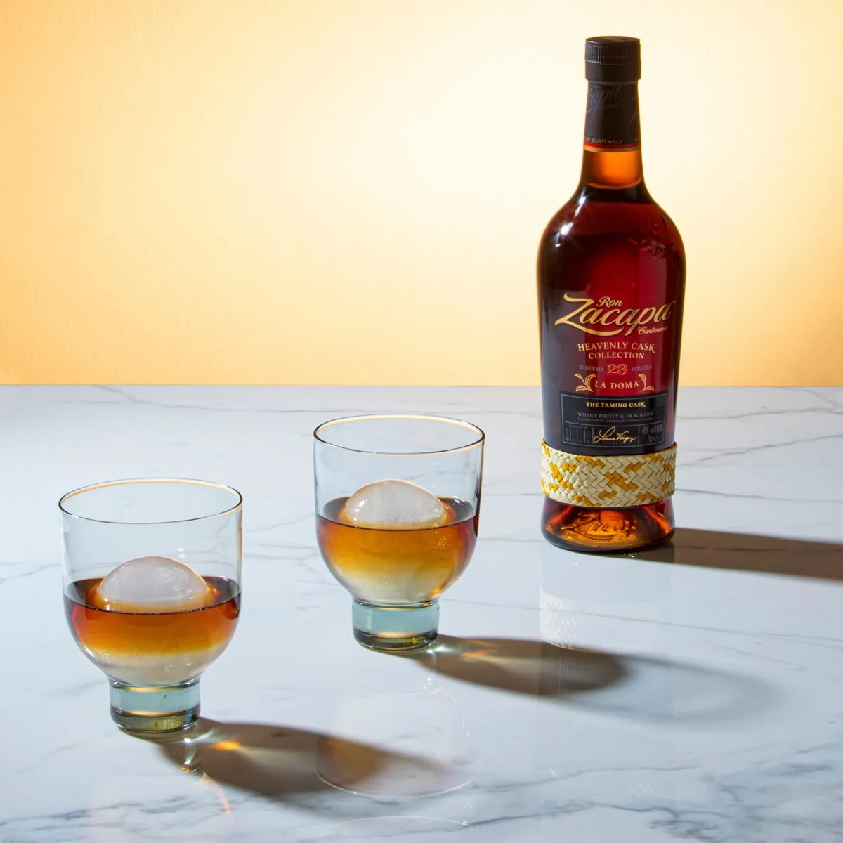 Garrafa de Zacapa na mesa ao lado de coquetel e cerejas