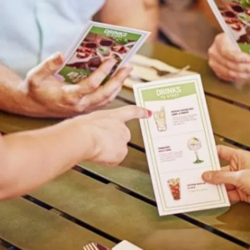   Food and Drinks Menu in a bar setting with a customer pointing to an item  