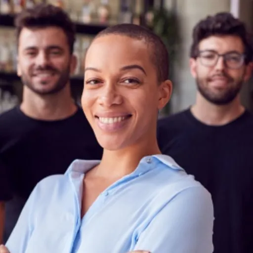 Woman standing in a leadership role with two male employees beside her  