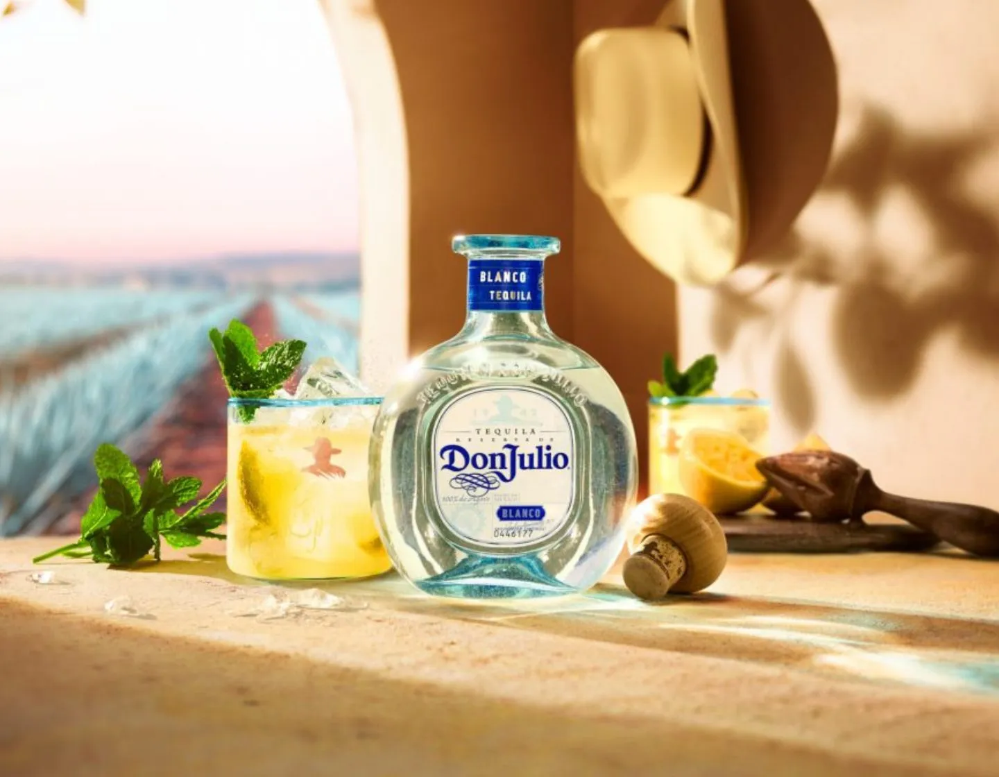 Garrafa de Don Julio Blanco ao lado de um coquetel com limão